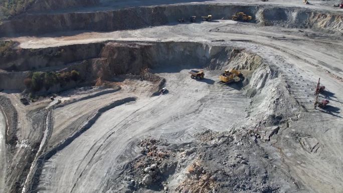 采石场开采铁矿石用的生产设备:挖掘机、自卸车。在采石场开采铁矿石的过程。