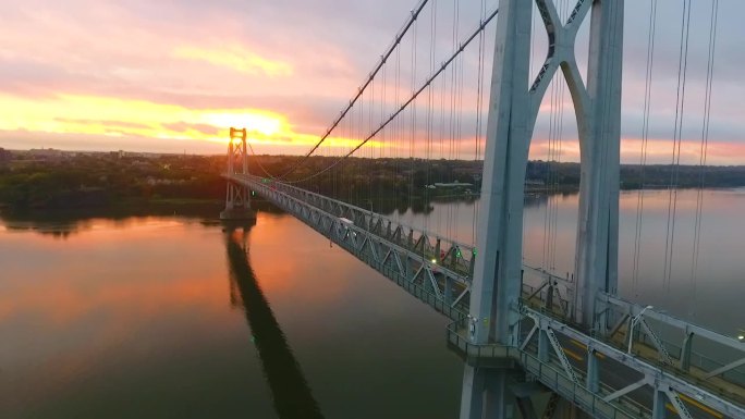 从低到高，在哈德逊河上令人惊叹的美国桥后面，粉色和金色的日出光