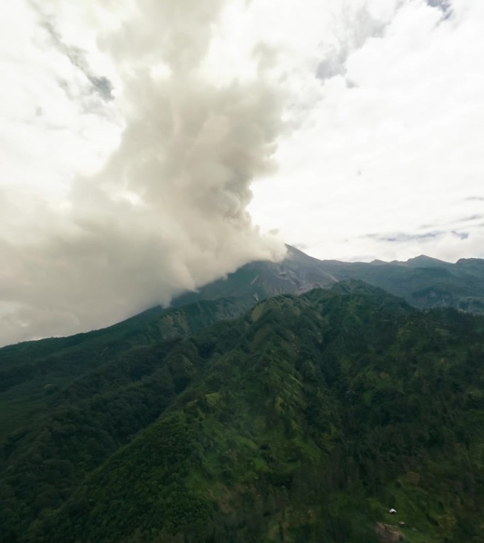 垂直视频。空中绿色丛林森林喷发火山冻结岩石熔岩