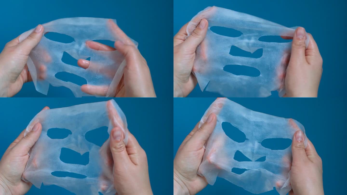 女性手持白色保湿面膜片，蓝色背景特写。