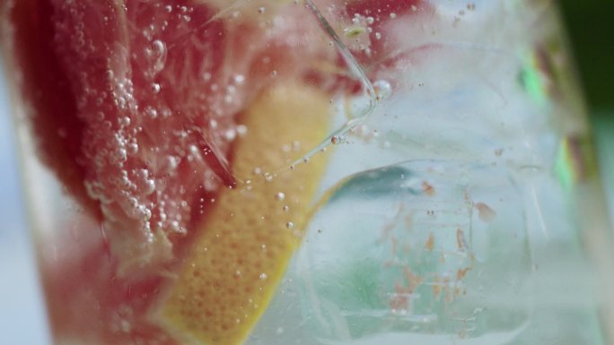 水果柚子茶与冰块混合气泡上升特写