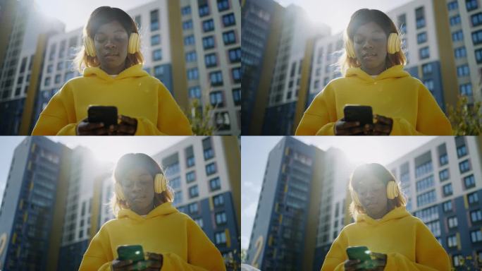 年轻的黑人女性社交媒体用户站在街上用智能手机上网