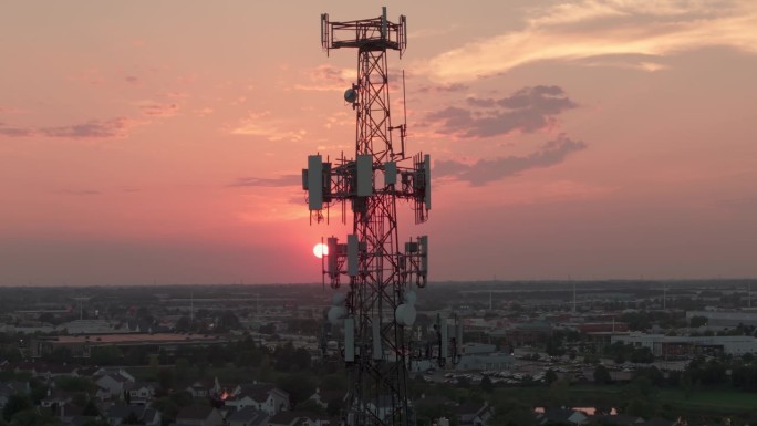 日落时分城市中的电视或无线电话塔。航拍无人机宽幅画面