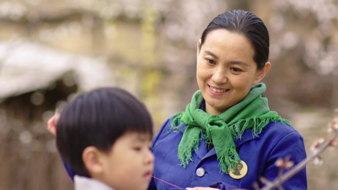 母亲在缝衣服儿子在玩树枝