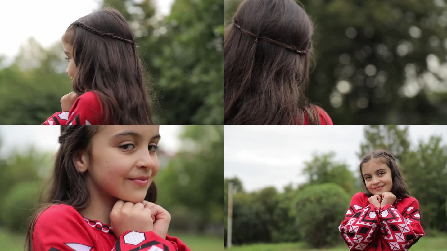 一个乌克兰小女孩穿着漂亮的红色绣花裙走在绿色的公园里。