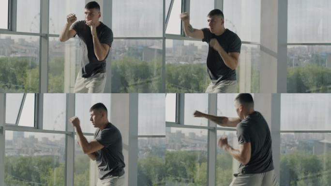 慢动作的有吸引力的年轻运动员训练手臂练习拳击动作在轻玻璃墙健身房