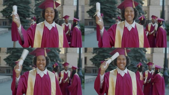 一个戴着毕业帽、穿着毕业服、喜出望外的非洲裔美国女士在校园里挥舞着文凭的慢动作肖像