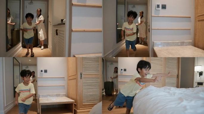 微笑的亚洲男孩在假日和家人一起跑到酒店的床上。