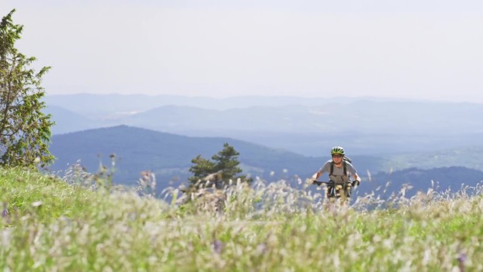 TS男子骑着他的电动山地车在阳光明媚的山上