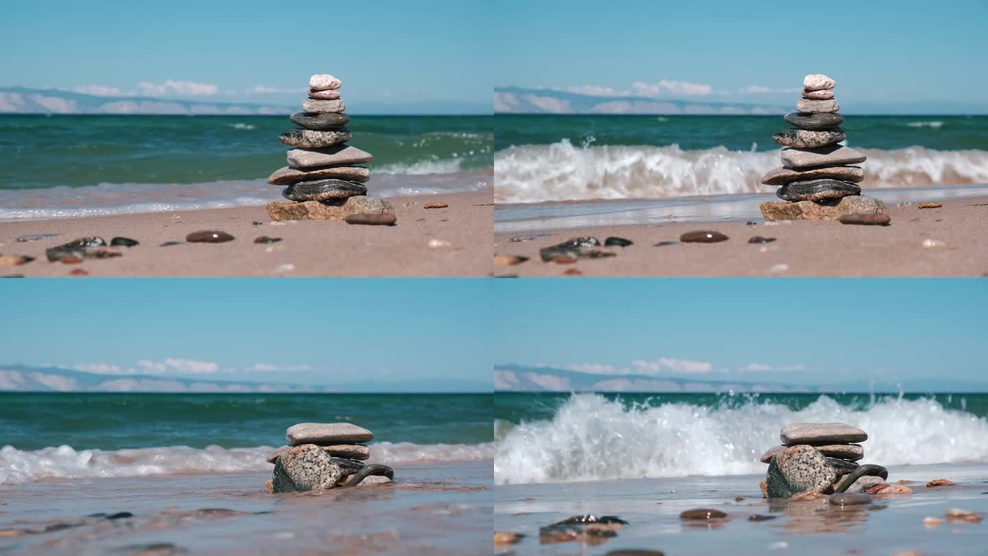 堆积的石头金字塔在来袭的波浪中倒塌。不平衡的概念，违反平衡。