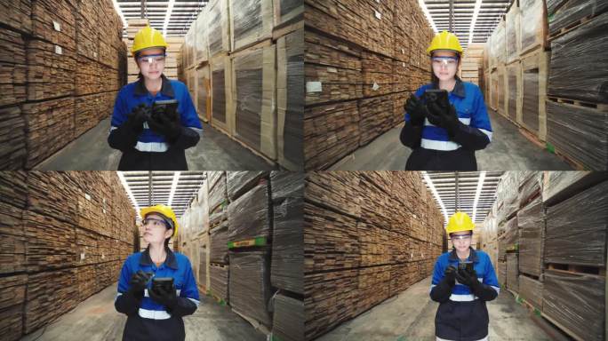 工厂工人检查大型仓库托盘中的加工木材产品。