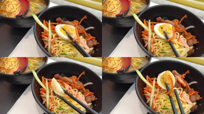 台湾风味冷干面半水煮蛋料理亚洲菜用黑盘子用筷子煮粉条从蔬菜黄瓜胡萝卜切成丝的健康食品