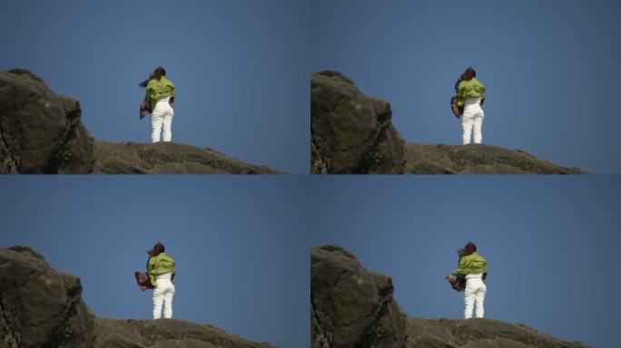 站在山顶岩石的女性背影