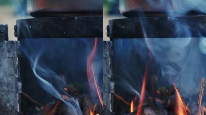 烧木头做饭用的炉子。用手把木头放进炉子。垂直视频