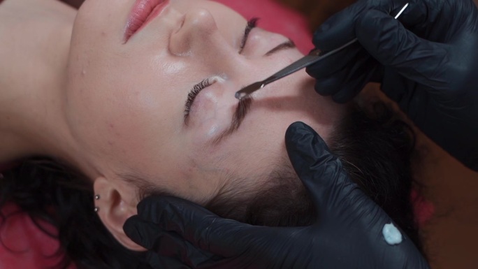 美女在美容师的分子眉毛修复程序特写