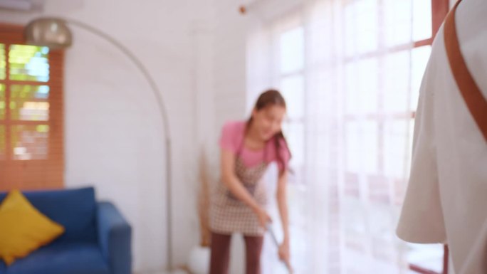 亚洲有吸引力的年轻男子和女子一起打扫室内。幸福的家庭，漂亮的夫妇用吸尘器清扫脏乱的地板，做家务和家务