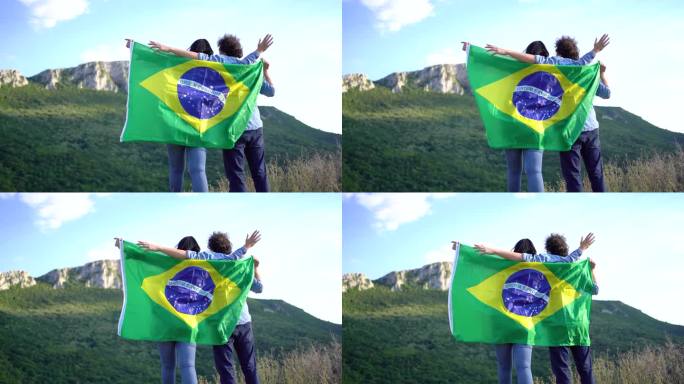 一对在山顶举着巴西国旗的夫妇