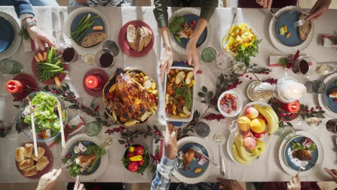 从上往下看，家人、孩子、朋友聚在家里吃圣诞大餐。不同的人享受美味的火鸡盛宴，分享故事。温馨节日庆典