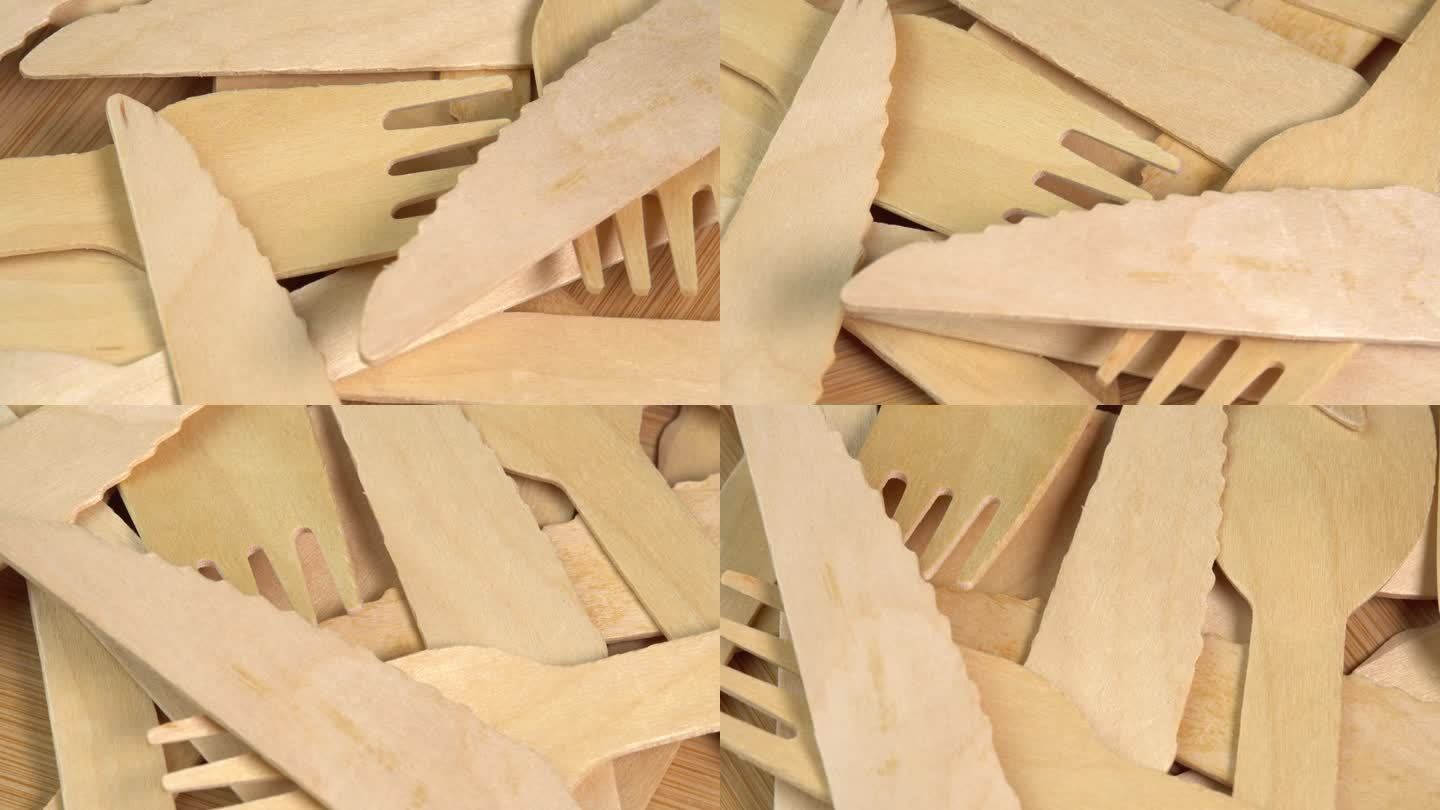 木质环保一次性餐具在木质餐桌上旋转。砧板上堆放着一堆木勺、刀叉。厨房、餐厅一次性生态餐具