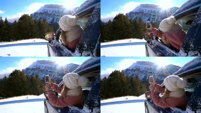 游客在车内用智能手机拍摄雪山，旅游目的地寒假