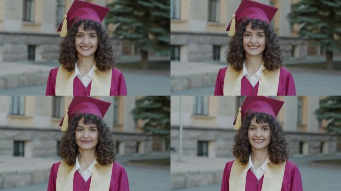 穿着毕业袍，戴着毕业帽，自信的年轻女子站在校园里微笑，感到自豪的慢动作肖像
