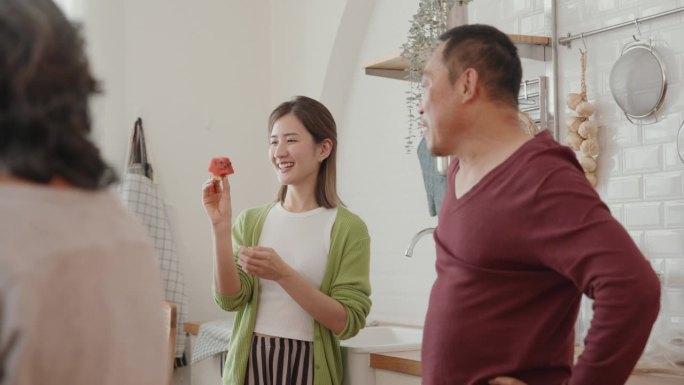 快乐的亚洲年轻女性和老人在家一起做素食:一个快乐的聚会，分享笑声和自制的幸福。