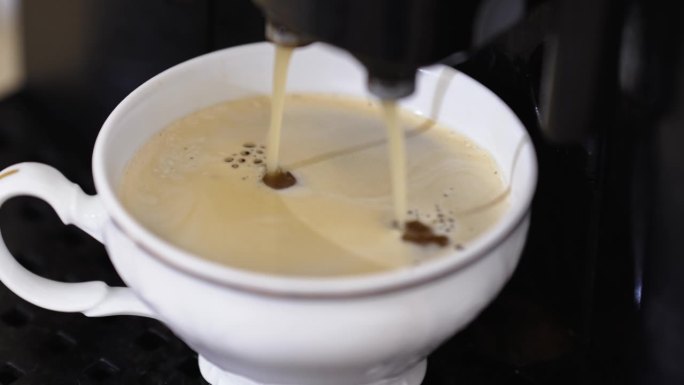咖啡机里的咖啡流进杯子里。