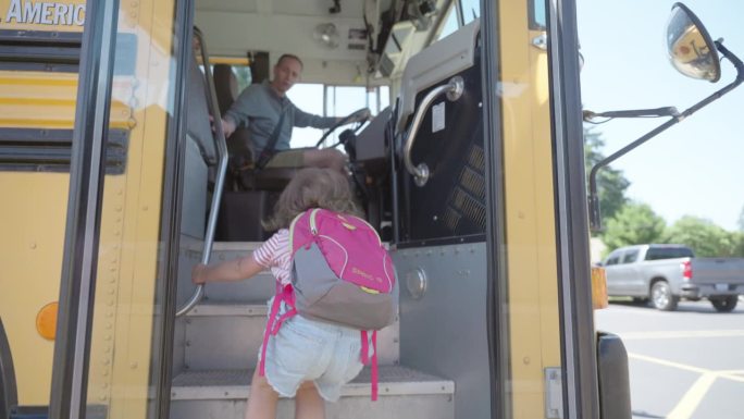 校车司机在迎接上校车的幼儿园学生