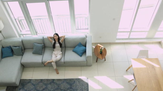 无忧无虑的女人在现代公寓享受休息