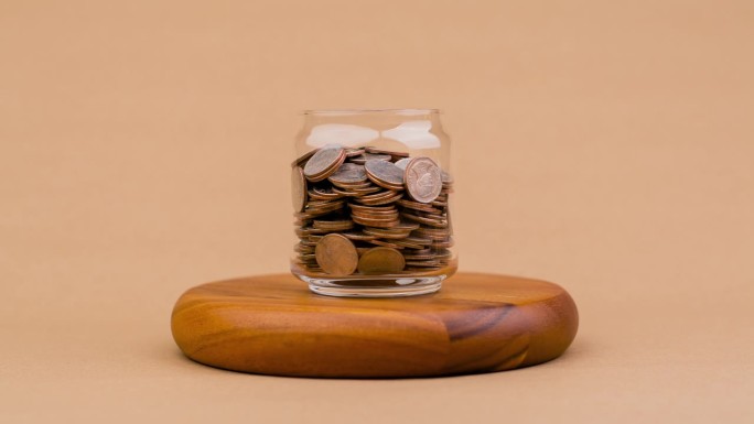 存钱硬币在玻璃罐里硬币银行收入红利现金现金流金融信贷金融汇率银行金融概念工资和生活费用