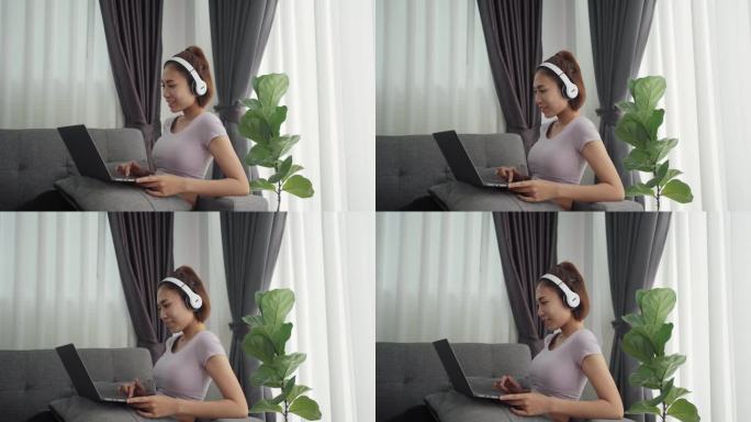 戴着无线耳机的女人面带微笑，在笔记本电脑上打字