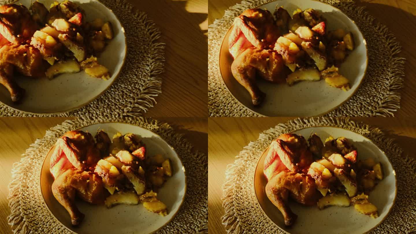 木桌上热气腾腾的烤鸡和蔬菜。金黄的烤鸡翅皮配蔬菜。美味简单的自制食物，电影般的场景