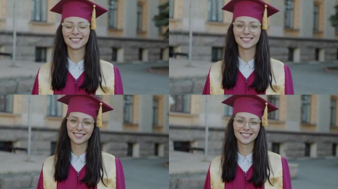 戴着毕业帽、穿着毕业礼服的聪明女孩在校园里微笑的慢动作肖像