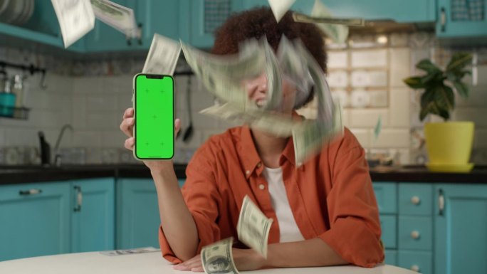 钱落在拿绿屏手机的黑人妇女身上。通过手机申请获得现金头奖。
