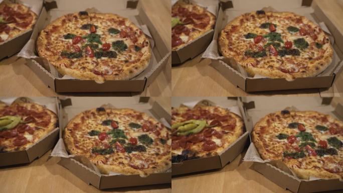 整张意大利辣香肠披萨和蔬菜披萨的俯视图，放在桌子上的硬纸板披萨盒里