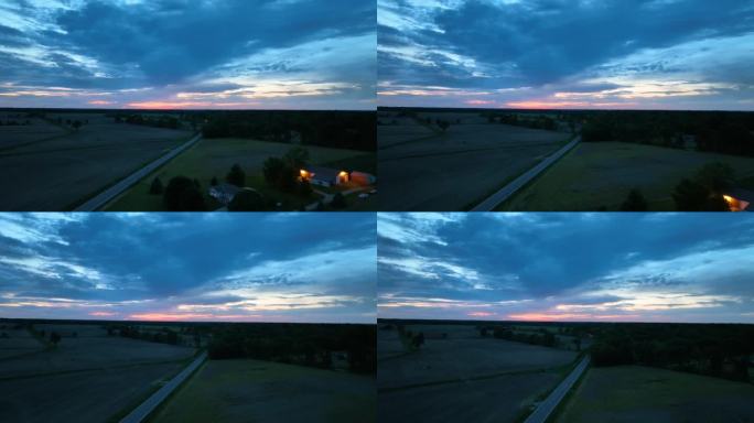 农家农舍上空的航拍视频，夕阳是深蓝色和粉红色的