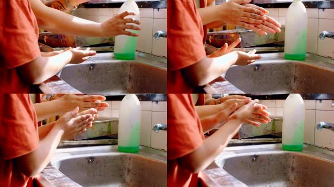 洗手，母亲和儿童用肥皂洗手，在家卫生保健和防病毒安全。在家庭厨房用水和消毒剂进行手部卫生、妈妈帮助和