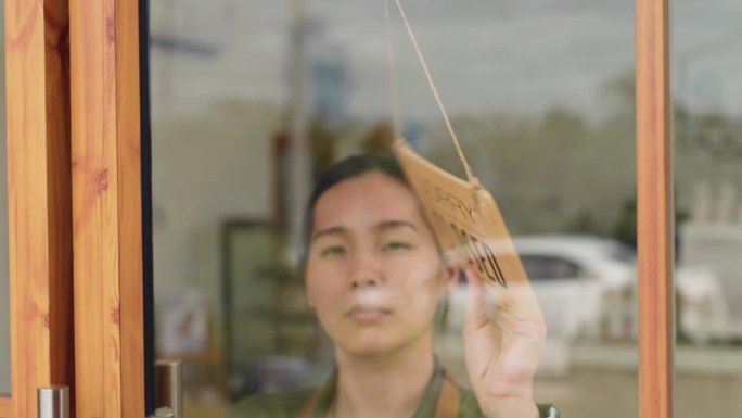 一个女人在她的商店门上挂了一个关门的牌子，商店关门了