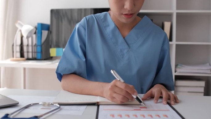 图为，一名亚洲女医科学生在医院大厅用笔记本电脑学习医学教科书。