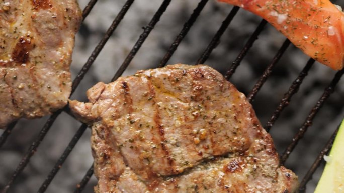 肉和蔬菜躺在烟雾缭绕的烤架上的俯视图