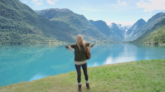 美女在冰湖户外用智能手机拍摄舞蹈视频疯狂视频博主女孩在社交媒体上分享自拍舞蹈视频享受挪威度假旅行冒险