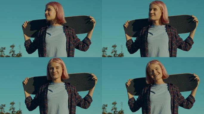 酷可爱的粉红色头发的女人的肖像与滑板的肩膀在户外