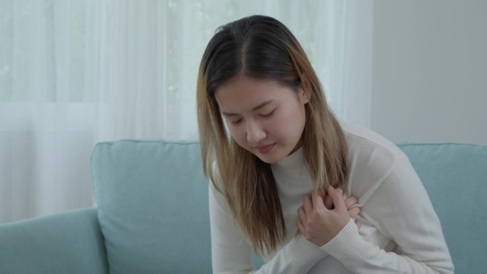 手抱胸有心脏病发作的症状，亚洲女性有心脏病引起的胸痛，渗漏、扩张、冠状动脉增大，按压胸部带有疼痛的表