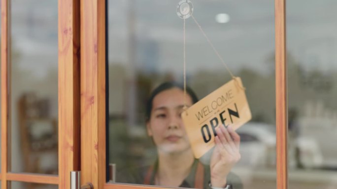 一个女人在她的商店门上挂了一个关门的牌子，商店关门了