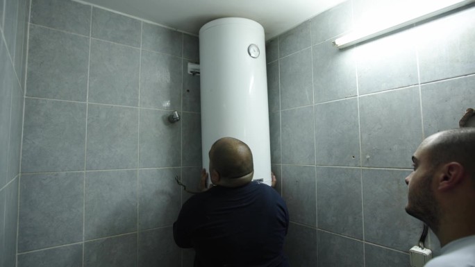 白人男性供暖工程师在客户的浴室里调节锅炉