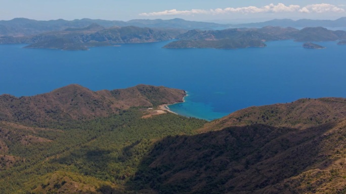 空中无人机拍摄的马尔马里斯半岛美丽的风景，山脉和丘陵，绿色的树林和弯弯曲曲的道路。环绕着爱琴海和地中