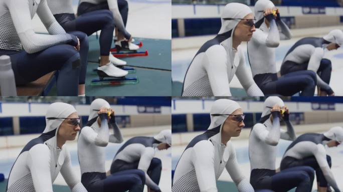 速滑运动员在训练前坐着看冰场