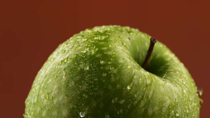 用慢动作旋转一个湿苹果
