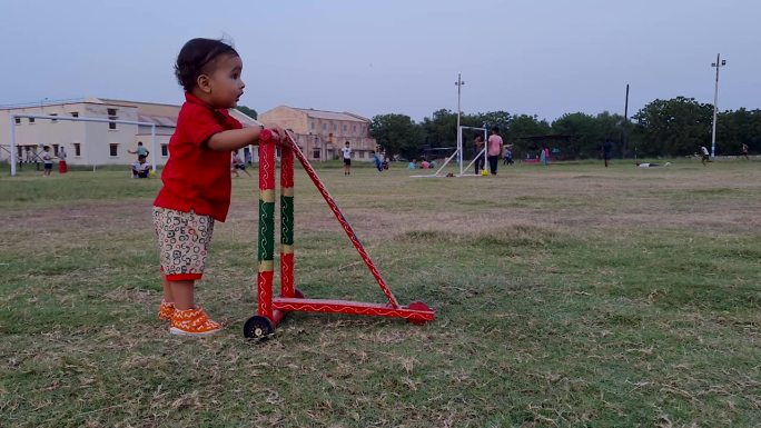 幼儿从不同的角度在户外用传统的木质学步车学习走路