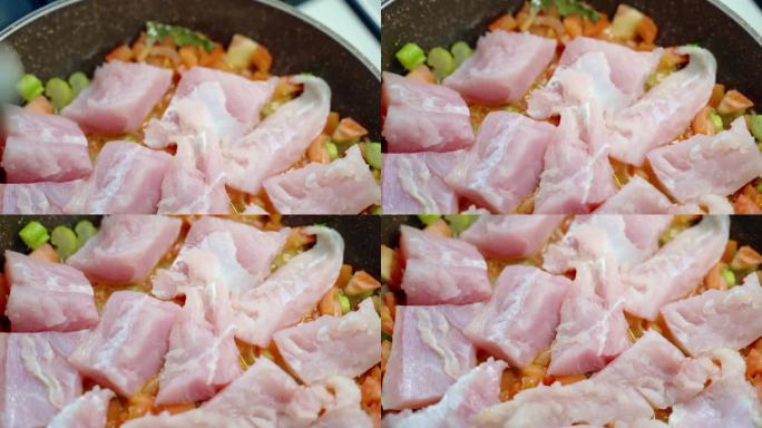 新鲜咸水鱼片与番茄、蒜、葱、芹菜碎一起在锅中炖煮，人用盐和胡椒粉调味白鱼肉，海鱼富含维生素、omeg